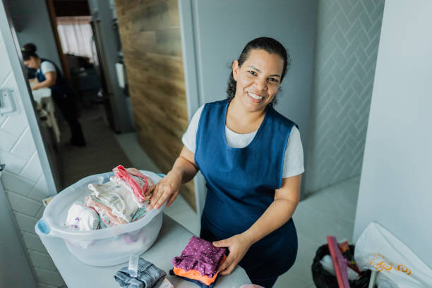 Portrait of a housekeeper organizing baby clothes in a nursery